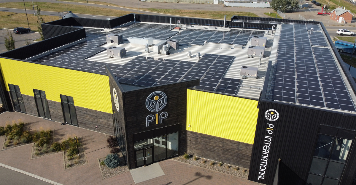 PIP International Small Facility. Dark wood building with yellow accents
