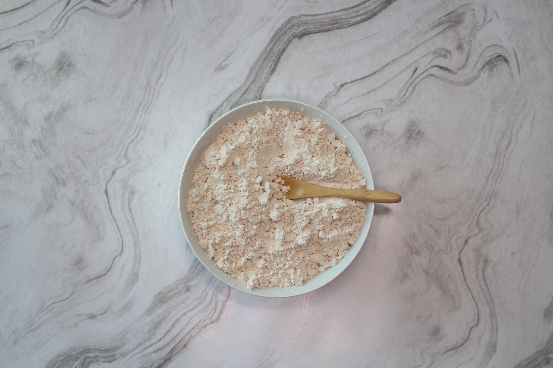 White Bowl with white pea protein on white marble background.