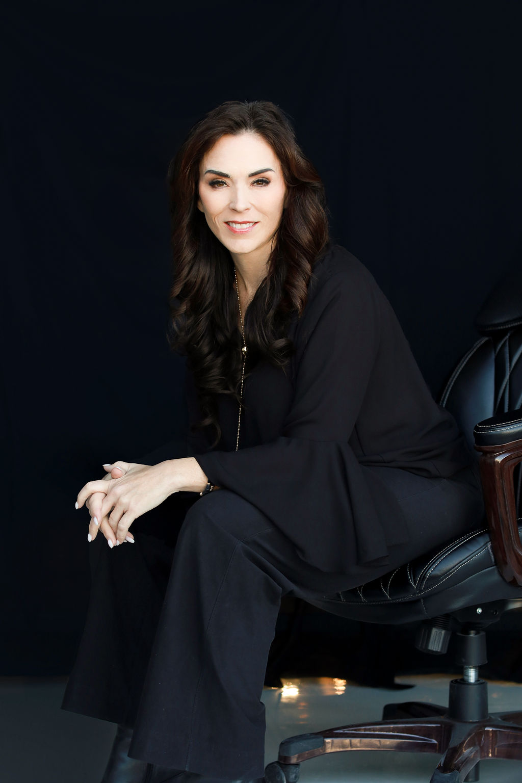 CEO Christine Lewington Sitting in chair on black background